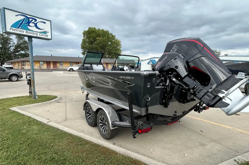 Slide: The Image of 2026 Lund 1875 Pro-V boat at Premier Boating Center, parked on a trailer. - 4