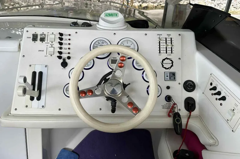 Slide: The Image of 1997 Fountain 29 Fever boat dashboard with steering wheel and control panel. - 12