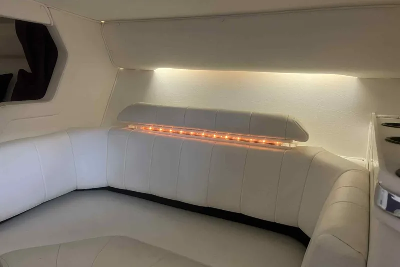 Slide: The Image of Interior of a 1997 Fountain 29 Fever boat with white seating and ambient lighting. - 7