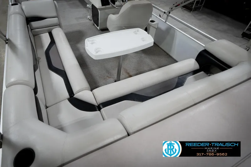 Slide: The Image of 1991 Godfrey SP2200 boat interior with beige seating and a white table. - 14