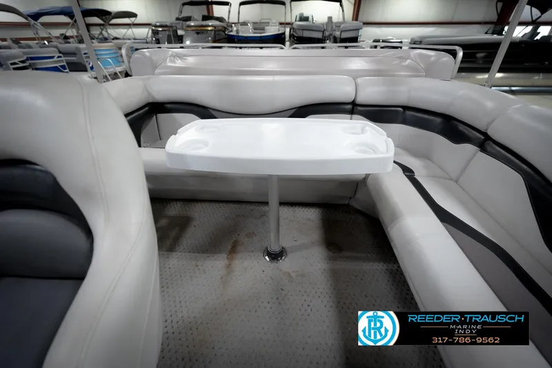 Slide: The Image of 1991 Godfrey SP2200 boat interior with white seating and table, Reeder-Trausch Marine logo visible. - 17