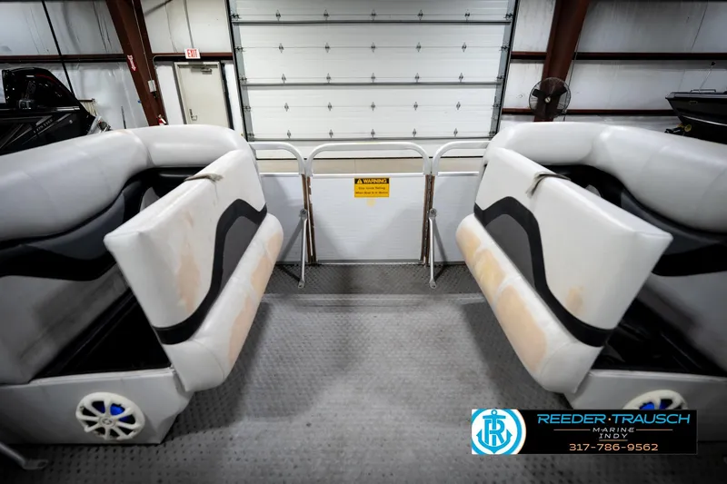 Slide: The Image of Interior of a 1991 Godfrey SP2200 boat with white seating and safety gate. - 21