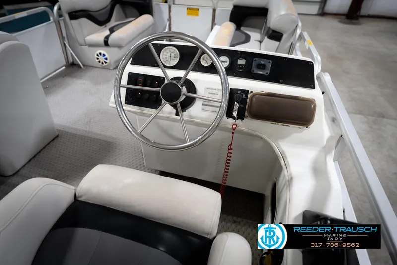 Slide: The Image of Interior of a 1991 Godfrey SP2200 boat with steering wheel and control panel. - 29