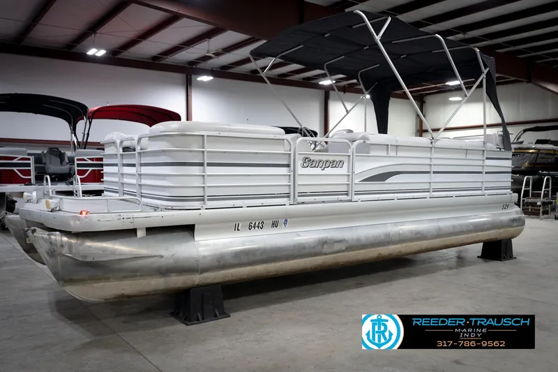 Slide: The Image of 1991 Godfrey SP2200 pontoon boat in showroom, featuring a canopy and sleek design. - 3