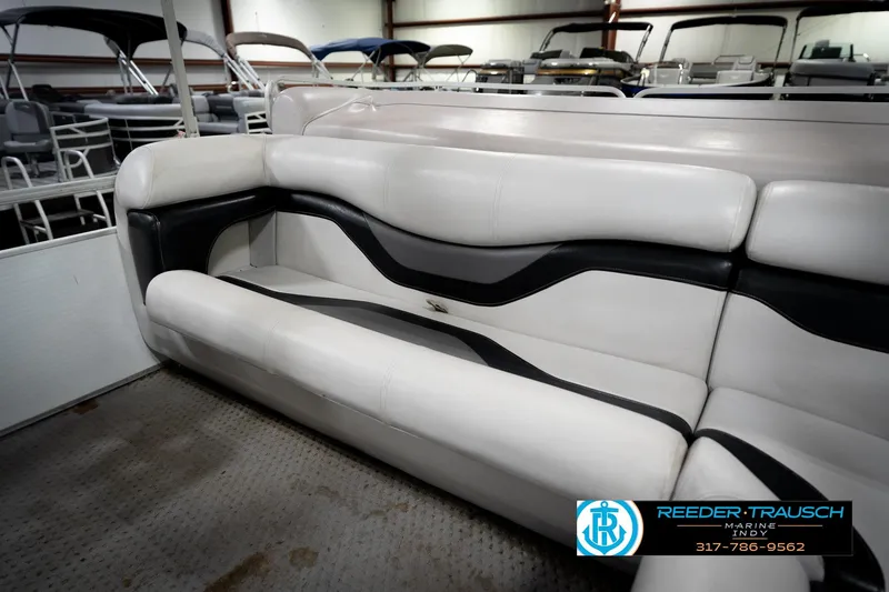 Slide: The Image of 1991 Godfrey SP2200 boat interior with white and black seating in showroom. - 40