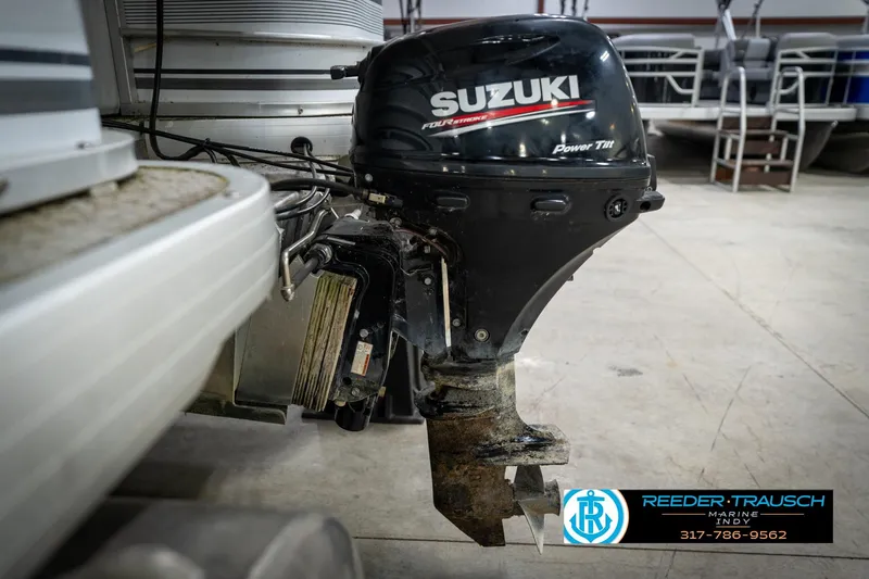 Slide: The Image of Outboard motor on a 1991 Godfrey SP2200 boat in a showroom setting. - 49