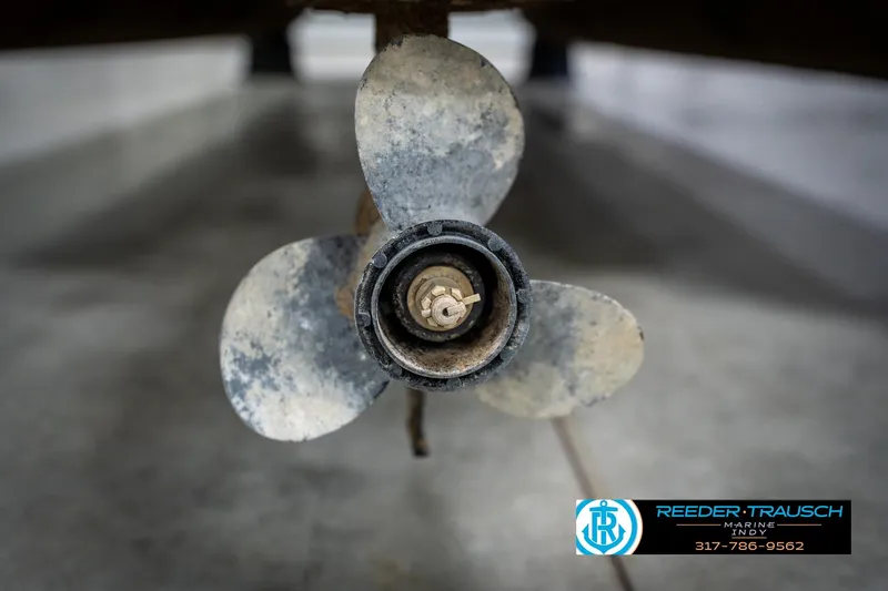 Slide: The Image of Close-up of a 1991 Godfrey SP2200 boat propeller in a workshop setting. - 52