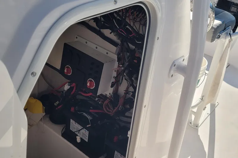 Slide: The Image of 2022 Aquasport 2100 Center Console electrical compartment with wiring and battery setup. - 25