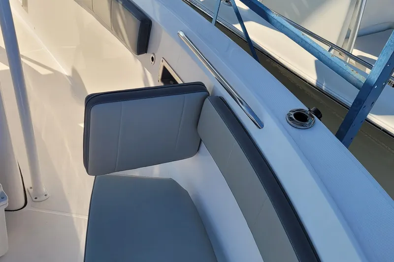 Slide: The Image of 2022 Aquasport 2100 Center Console boat interior with cushioned seating and rod holder. - 38