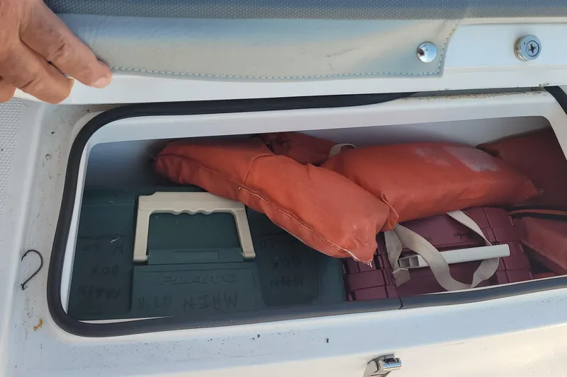 Slide: The Image of Storage compartment in 2022 Aquasport 2100 Center Console with life jackets and gear. - 40