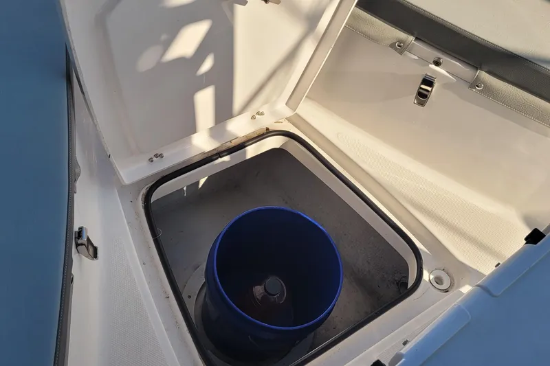 Slide: The Image of Open storage compartment on 2022 Aquasport 2100 Center Console boat with blue bucket inside. - 41