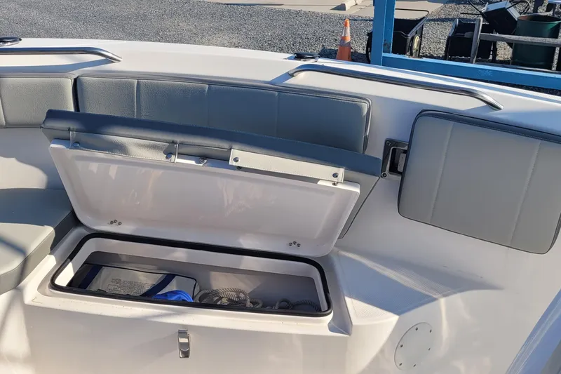 Slide: The Image of 2022 Aquasport 2100 Center Console boat with open storage compartment and cushioned seating. - 47