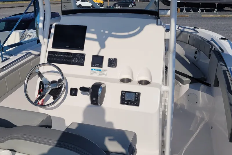 Slide: The Image of 2022 Aquasport 2100 Center Console boat dashboard with steering wheel and electronic controls. - 49