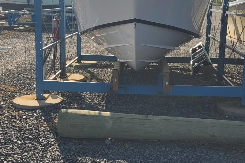 Slide: The Image of 2022 Aquasport 2100 Center Console boat on a storage rack, gravel ground. - 56