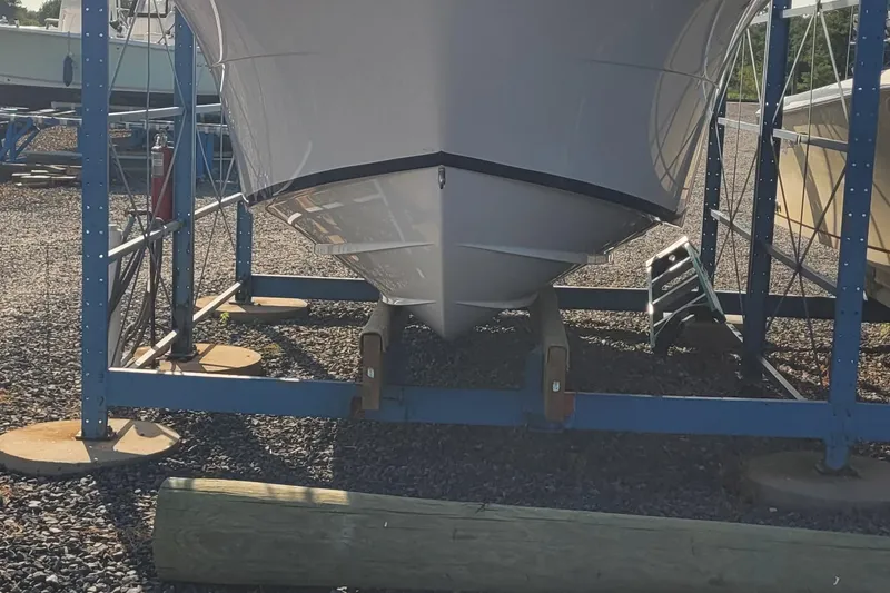 Slide: The Image of 2022 Aquasport 2100 Center Console boat on a storage rack. - 58