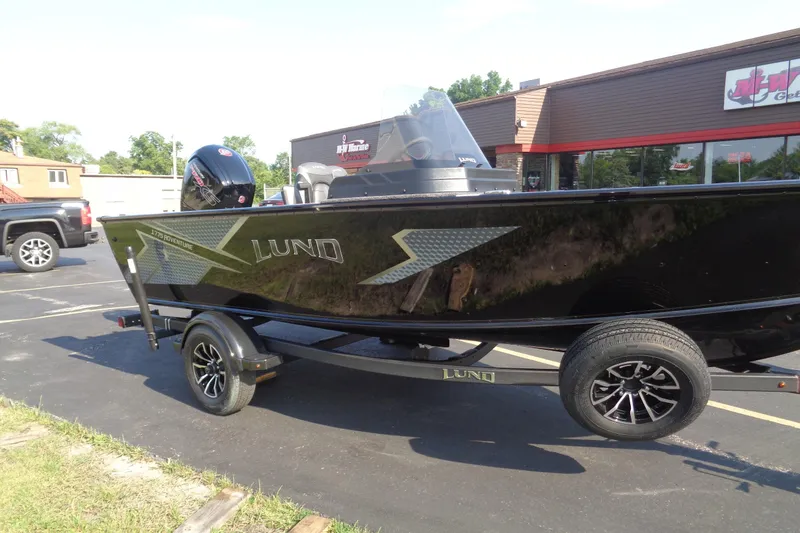 Slide: The Image of 2026 Lund 1775 Adventure SS boat on trailer, parked outside a store. - 7