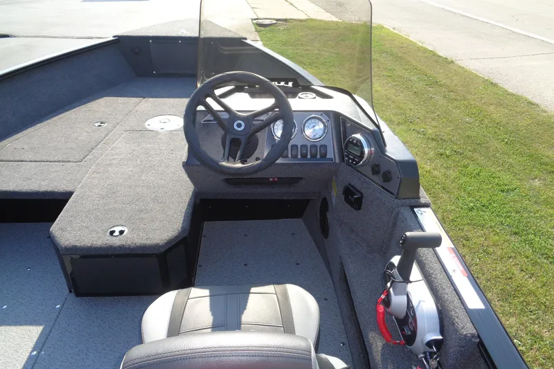 Slide: The Image of 2026 Lund 1775 Adventure SS boat interior with steering wheel and dashboard controls. - 9
