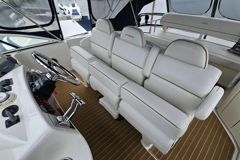 Slide: The Image of 2007 Silverton 38 Sport Bridge interior with white seating and sleek steering wheel. - 11