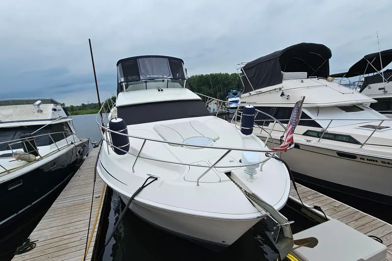 Slide: The Image of 2007 Silverton 38 Sport Bridge yacht docked at marina, surrounded by other boats. - 2