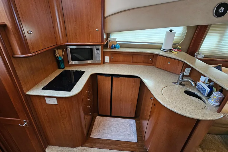 Slide: The Image of 2007 Silverton 38 Sport Bridge yacht kitchen with wood cabinetry and modern appliances. - 21