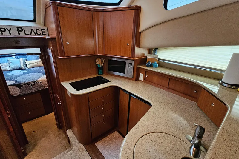 Slide: The Image of 2007 Silverton 38 Sport Bridge yacht kitchen with wood cabinetry and modern appliances. - 22