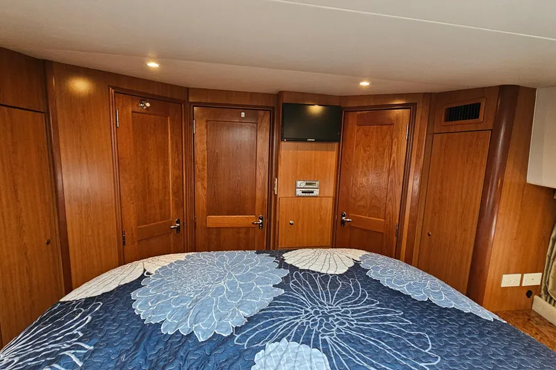 Slide: The Image of Interior of 2007 Silverton 38 Sport Bridge with wood paneling and floral bedspread. - 26