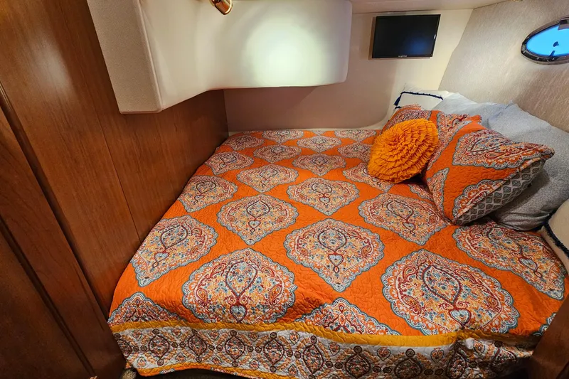Slide: The Image of 2007 Silverton 38 Sport Bridge cabin with vibrant orange patterned bedding and cozy decor. - 27