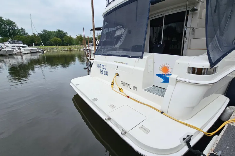 Slide: The Image of 2007 Silverton 38 Sport Bridge docked, featuring "Don't Tell the Kids" text on the stern. - 3
