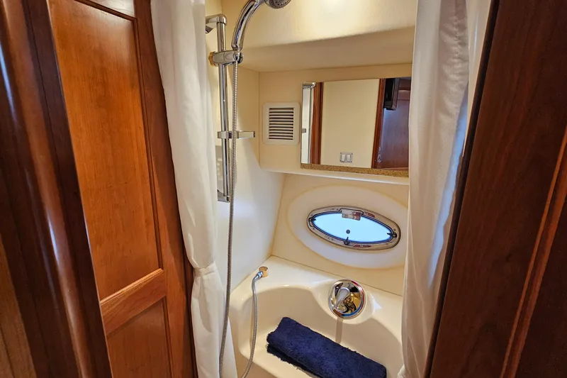 Slide: The Image of Shower area in 2007 Silverton 38 Sport Bridge yacht with wooden accents and porthole window. - 31