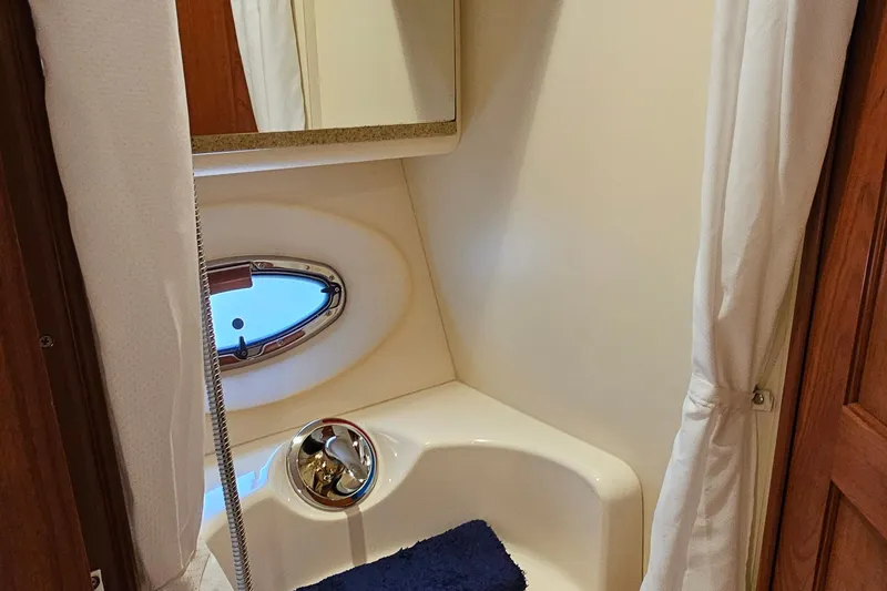 Slide: The Image of 2007 Silverton 38 Sport Bridge bathroom with porthole and shower curtain. - 32