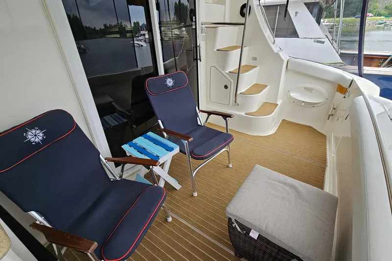 Slide: The Image of 2007 Silverton 38 Sport Bridge yacht deck with chairs and steps, overlooking water. - 5