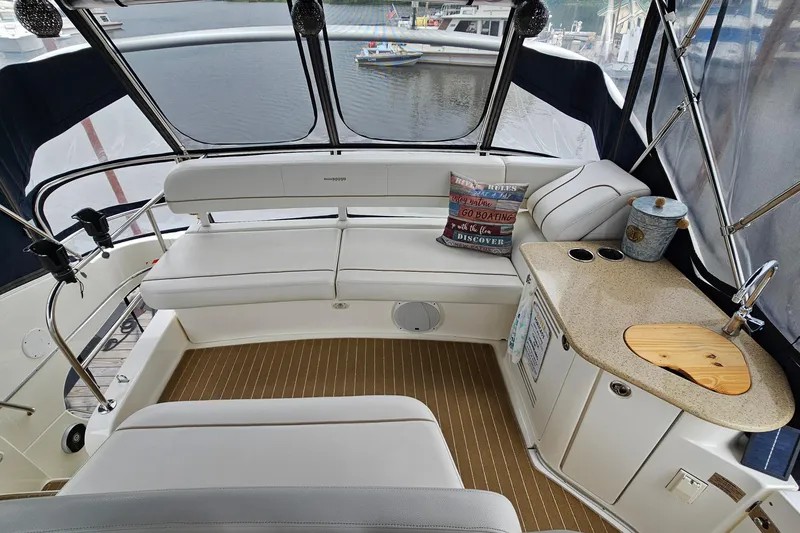 Slide: The Image of 2007 Silverton 38 Sport Bridge interior with seating, kitchenette, and marina view. - 8