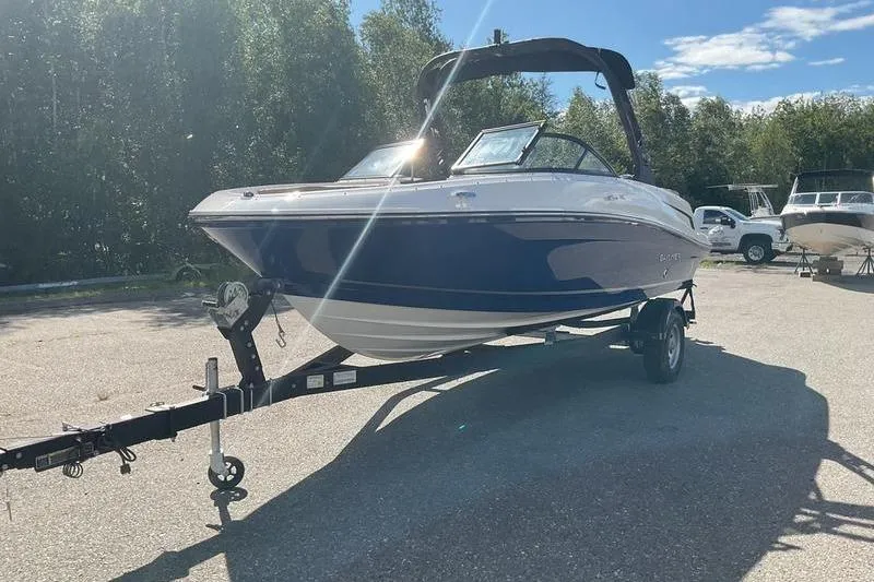 The Image of 2025 Bayliner VR5 OB boat on trailer, parked outdoors under clear sky. - 0