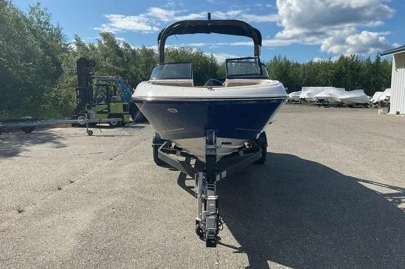 Slide: The Image of 2025 Bayliner VR5 OB boat on trailer under clear sky. - 2