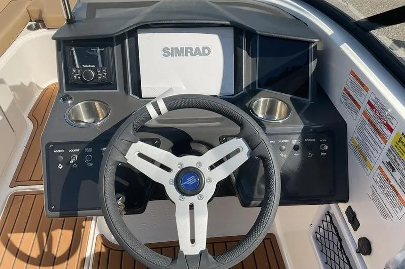 Slide: The Image of 2025 Bayliner VR5 OB boat dashboard with steering wheel and Simrad display. - 3