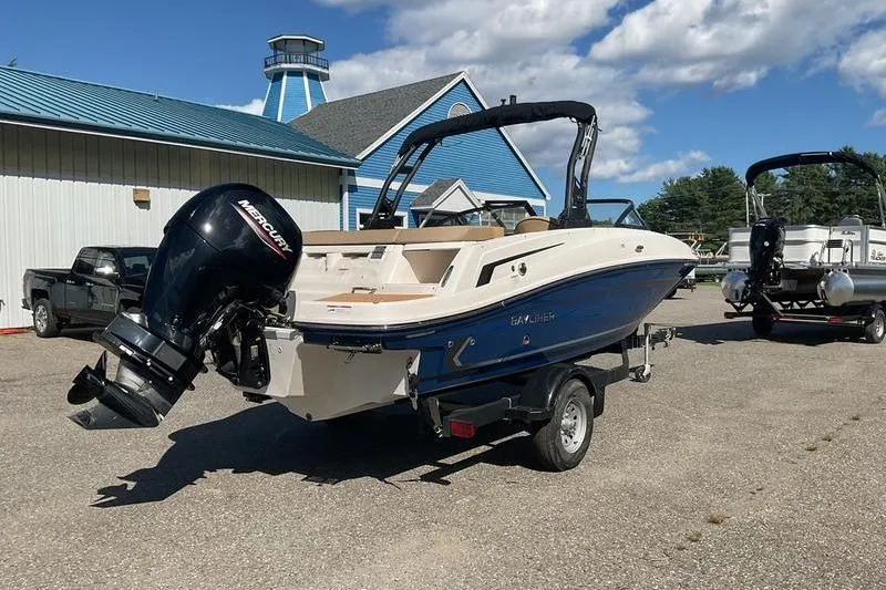Slide: The Image of 2025 Bayliner VR5 OB boat with Mercury outboard motor on trailer, parked outdoors. - 4