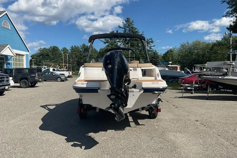 Slide: The Image of 2025 Bayliner VR5 OB boat with outboard motor in a sunny parking lot. - 6