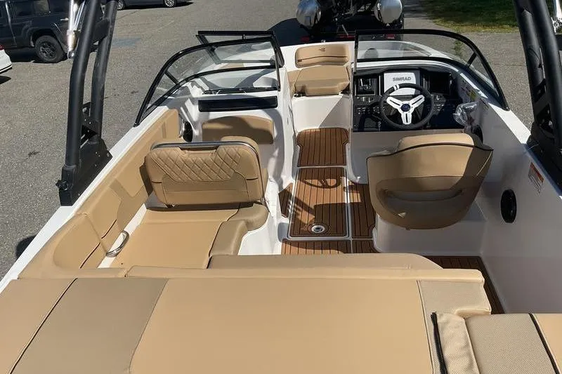 Slide: The Image of 2025 Bayliner VR5 OB boat interior with tan seating and wood accents. - 8
