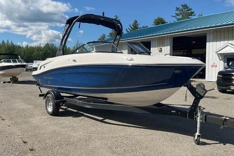 Slide: The Image of 2025 Bayliner VR5 OB boat on trailer, parked outdoors near a building. - 9