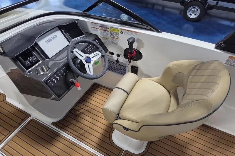 Slide: The Image of 2025 Bayliner VR5 OB boat cockpit with steering wheel and beige captain's chair. - 11