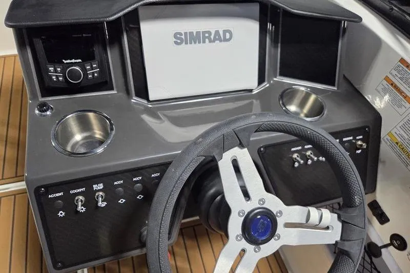 Slide: The Image of 2025 Bayliner VR5 OB dashboard with Simrad display and steering wheel. - 12