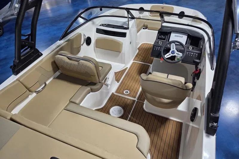 Slide: The Image of 2025 Bayliner VR5 OB boat interior with beige seating and wood-style flooring. - 13