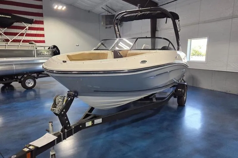 Slide: The Image of 2025 Bayliner VR5 OB boat on trailer in showroom with blue floor. - 6