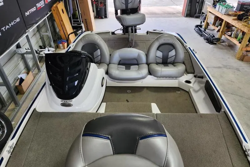 Slide: The Image of 2017 Nitro Z17 boat interior with gray seating and steering console in a garage. - 8