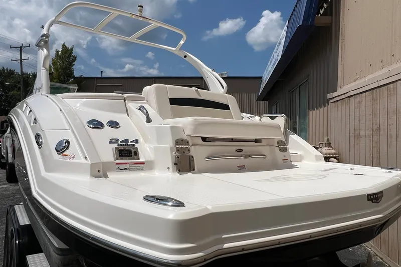 Slide: The Image of 2016 Chaparral 244 Sunesta boat with sleek design, parked outdoors under a blue sky. - 16