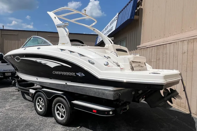Slide: The Image of 2016 Chaparral 244 Sunesta boat on trailer, parked outdoors, under clear blue sky. - 17