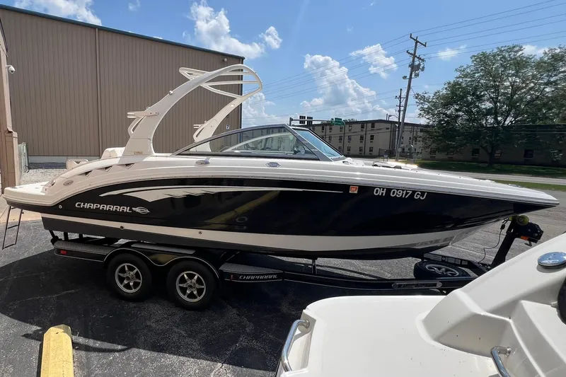 Slide: The Image of 2016 Chaparral 244 Sunesta boat on trailer, parked outdoors under a clear sky. - 18