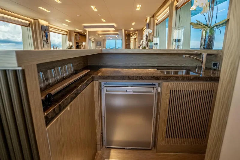Slide: The Image of Luxurious yacht interior with modern kitchen, featuring wood finishes and large windows. Horizon RP120, 2017. - 18