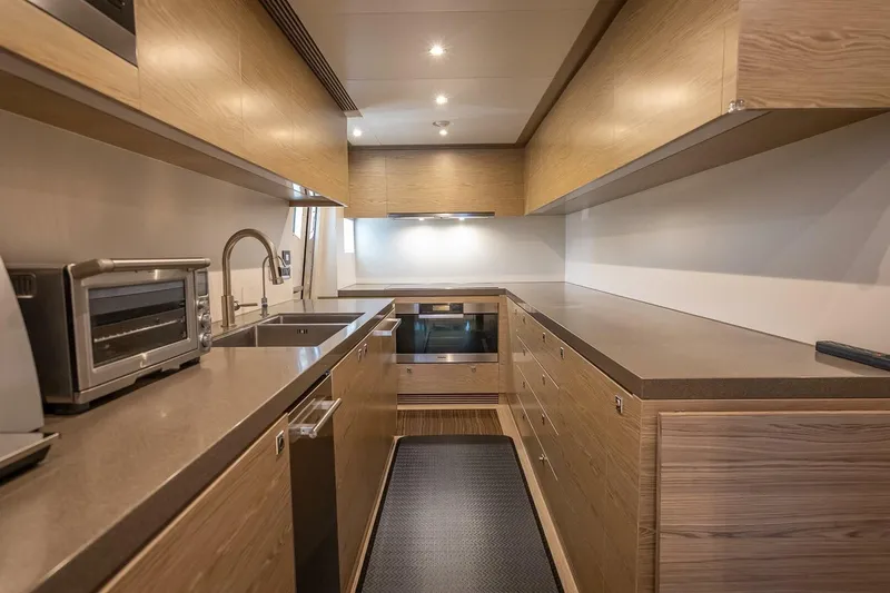 Slide: The Image of Modern galley kitchen on 2017 Horizon RP120 yacht with wood cabinetry and stainless steel appliances. - 22