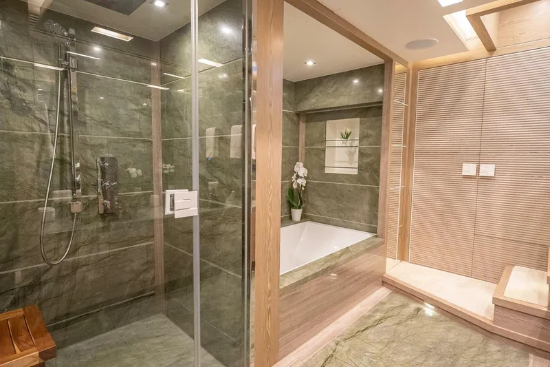 Slide: The Image of Luxurious bathroom with glass shower, marble walls, and elegant bathtub in Horizon RP120 yacht. - 38